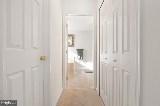 hallway featuring light colored carpet