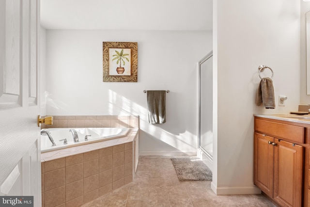 full bath with a stall shower, tile patterned flooring, a garden tub, and vanity