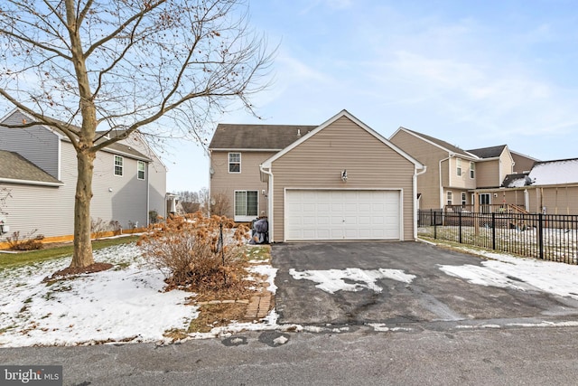 view of front of home featuring driveway, an attached garage, and fence