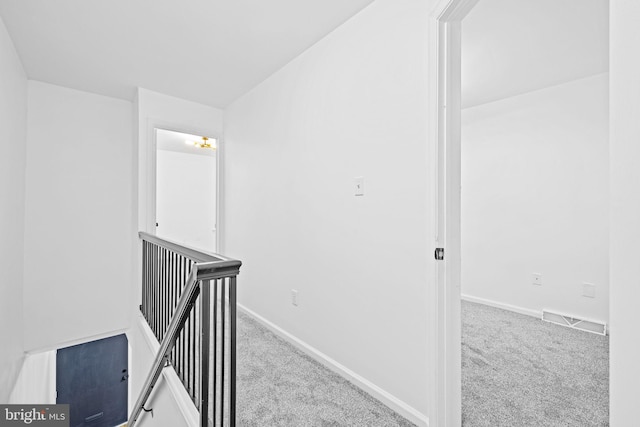 hallway featuring light colored carpet