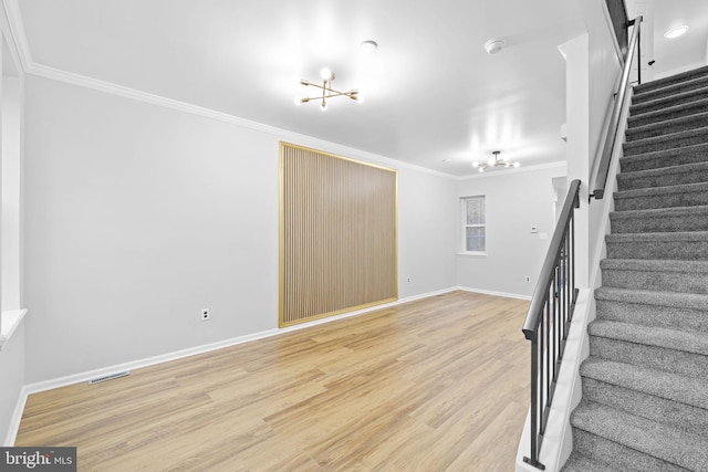 stairs featuring crown molding, wood-type flooring, and a notable chandelier