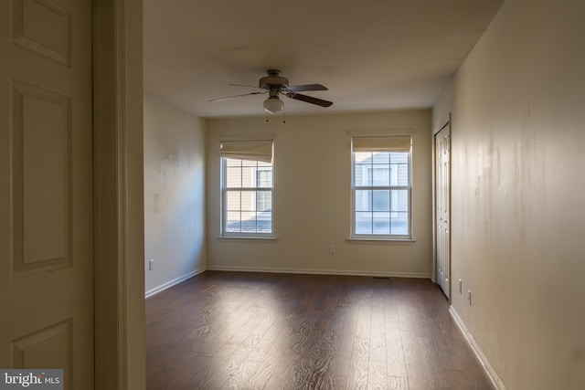 empty room featuring ceiling fan and dark hardwood / wood-style floors