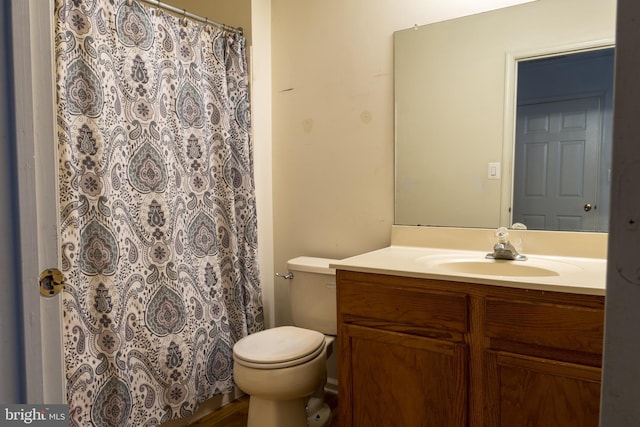 bathroom featuring a shower with shower curtain, vanity, and toilet