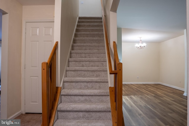 stairway with a notable chandelier and wood-type flooring