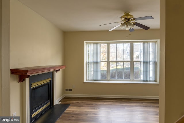 unfurnished living room with ceiling fan and wood-type flooring