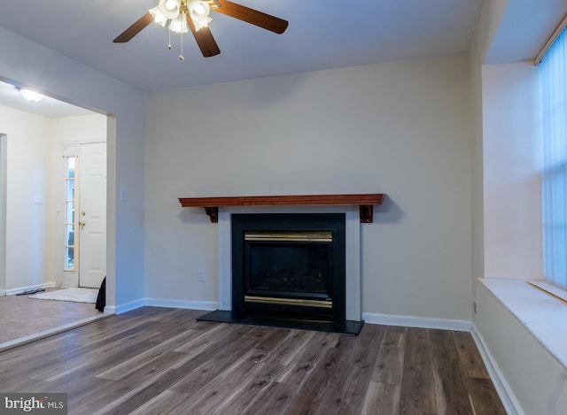 unfurnished living room with dark hardwood / wood-style floors and ceiling fan