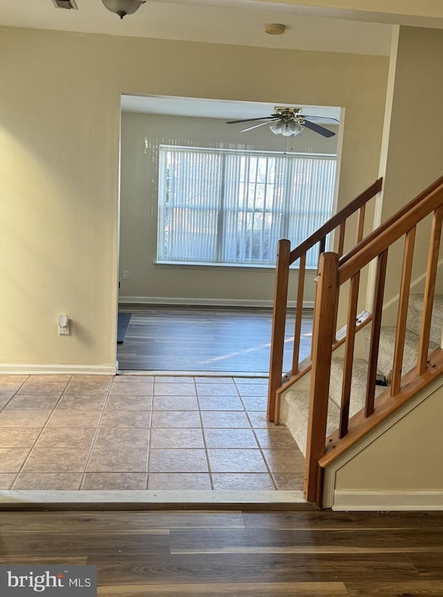 stairway with tile patterned floors and ceiling fan