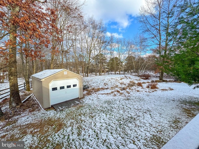 yard covered in snow featuring a garage and an outdoor structure