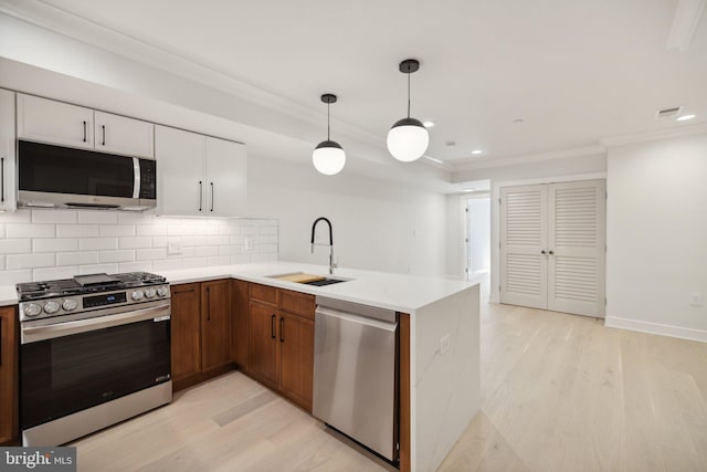 kitchen featuring white cabinetry, sink, stainless steel appliances, and light hardwood / wood-style floors