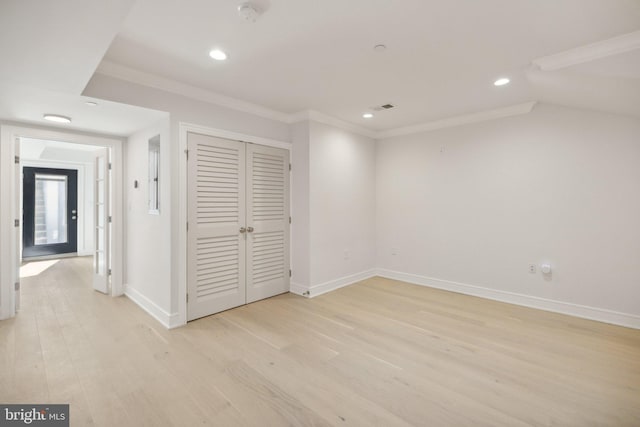 unfurnished bedroom featuring a closet, ornamental molding, and light wood-type flooring