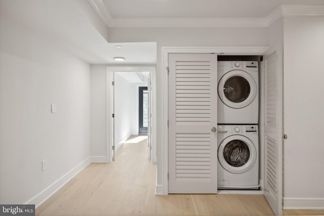 laundry room featuring light hardwood / wood-style floors, ornamental molding, and stacked washer / dryer