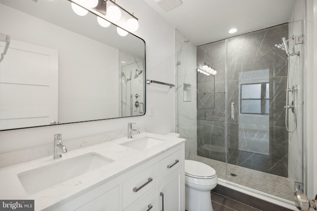 bathroom with vanity, toilet, and a shower with door