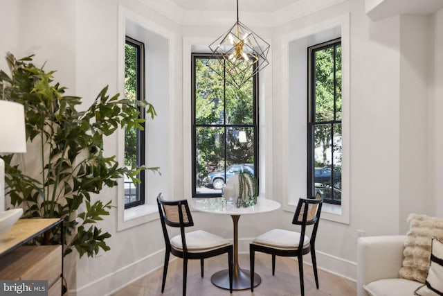 dining area with a notable chandelier and light hardwood / wood-style floors