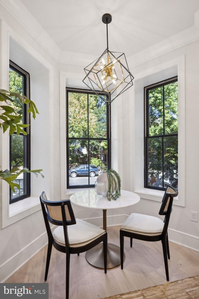 dining space with a notable chandelier, a wealth of natural light, and light hardwood / wood-style flooring