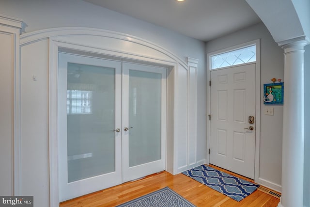 entryway with hardwood / wood-style floors and decorative columns