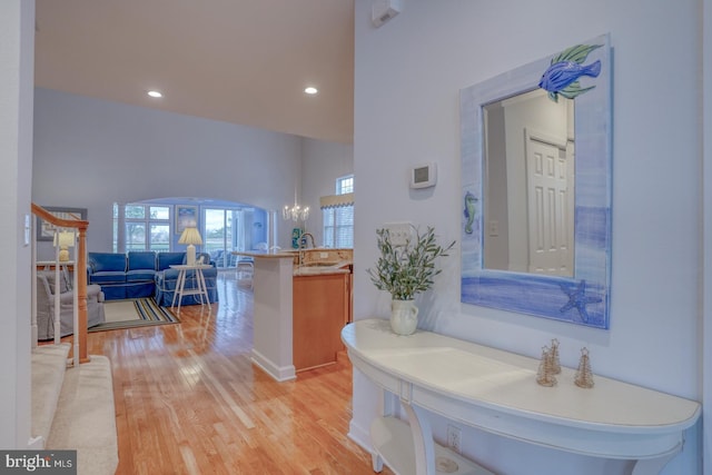 bathroom with a wealth of natural light, sink, a notable chandelier, and hardwood / wood-style flooring