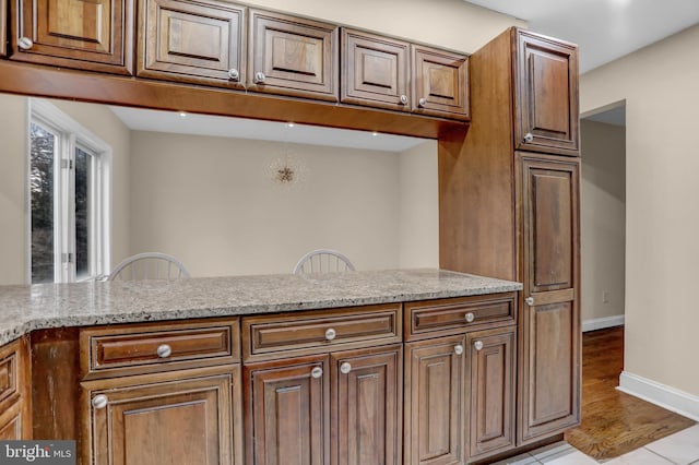 kitchen with light stone countertops and light wood-type flooring