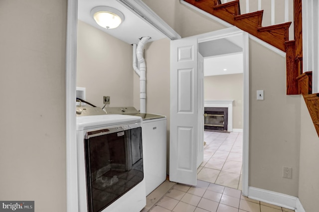 clothes washing area with light tile patterned flooring and independent washer and dryer