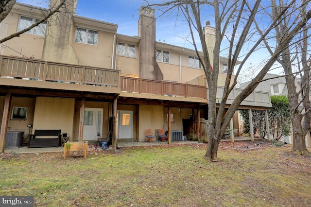 back of property featuring cooling unit and a yard