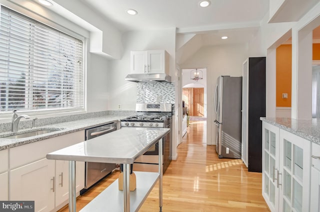 kitchen featuring light stone countertops, appliances with stainless steel finishes, sink, light hardwood / wood-style flooring, and white cabinets