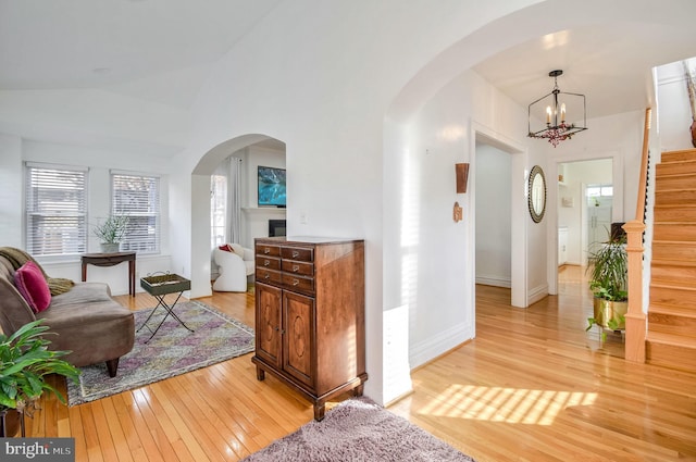 foyer entrance featuring light hardwood / wood-style flooring, a chandelier, and lofted ceiling