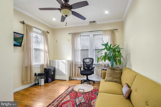 sitting room with crown molding, light hardwood / wood-style flooring, ceiling fan, and radiator heating unit