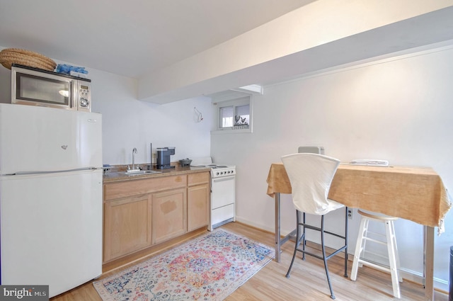 kitchen featuring light hardwood / wood-style floors, white appliances, sink, and light brown cabinets