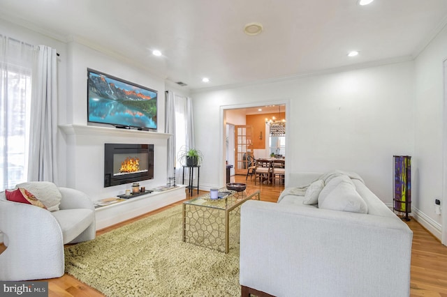 living room featuring plenty of natural light, light hardwood / wood-style floors, and ornamental molding