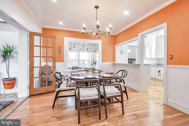 dining room featuring a chandelier, crown molding, and light hardwood / wood-style floors