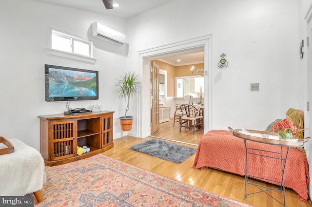 living room with crown molding, a wall mounted air conditioner, and hardwood / wood-style flooring