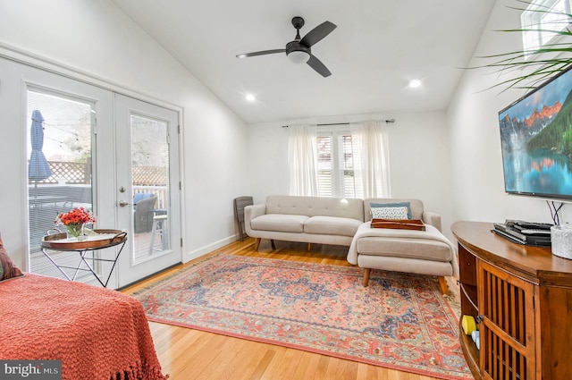 living room with hardwood / wood-style flooring, ceiling fan, lofted ceiling, and french doors