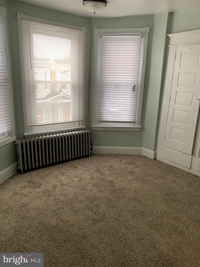 spare room with carpet and radiator heating unit