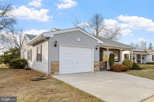 single story home featuring covered porch, a garage, and a front lawn