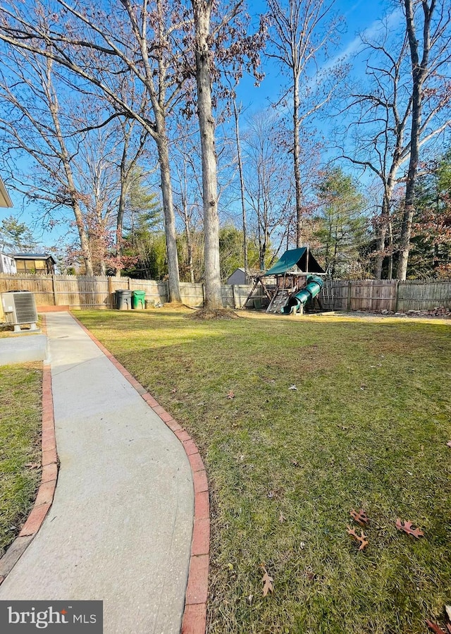 view of yard with a playground and central air condition unit