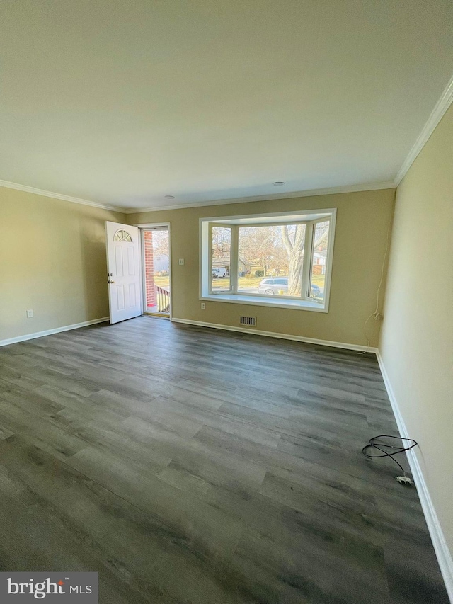 spare room with crown molding and dark wood-type flooring