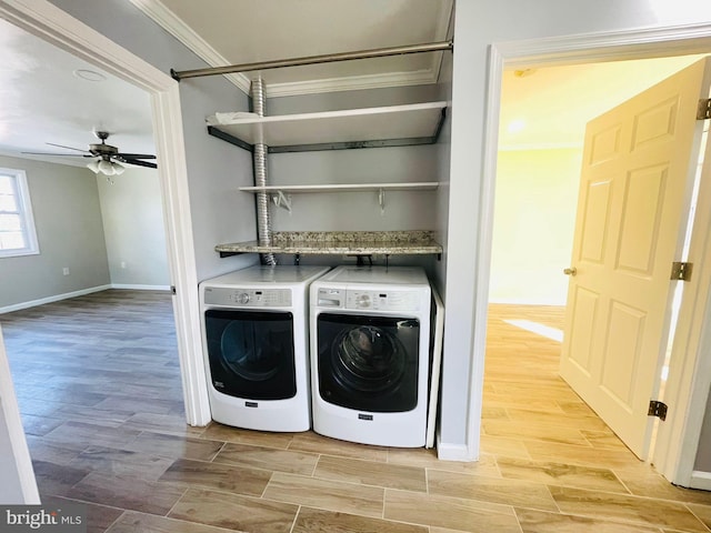 laundry area featuring ceiling fan, light hardwood / wood-style floors, ornamental molding, and washing machine and clothes dryer