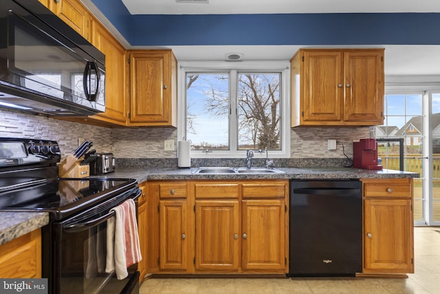 kitchen featuring decorative backsplash, sink, plenty of natural light, and black appliances