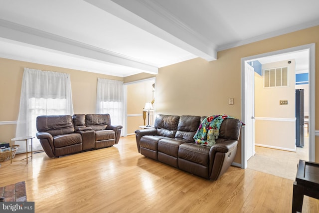 living room featuring beamed ceiling, light hardwood / wood-style floors, and ornamental molding