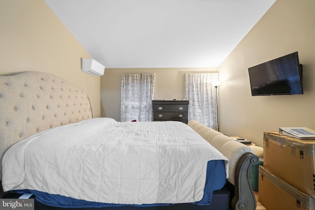 bedroom with a wall mounted air conditioner and vaulted ceiling