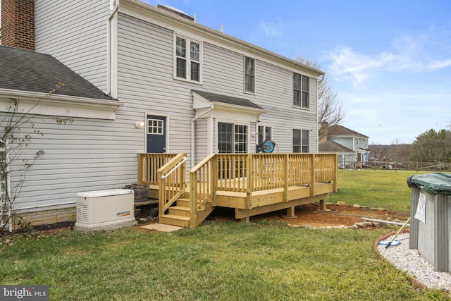 back of property featuring a lawn and a wooden deck