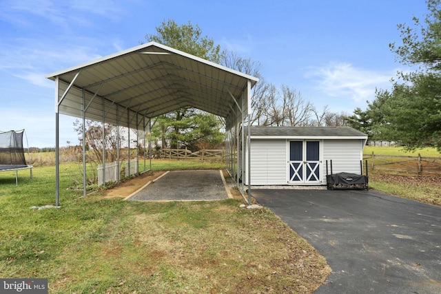 view of outdoor structure with a lawn and a carport