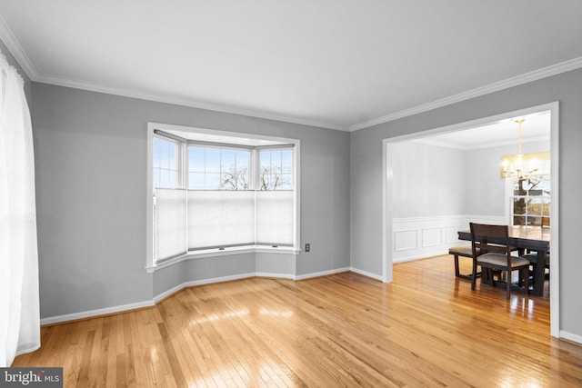 spare room featuring wood-type flooring, a wealth of natural light, and ornamental molding