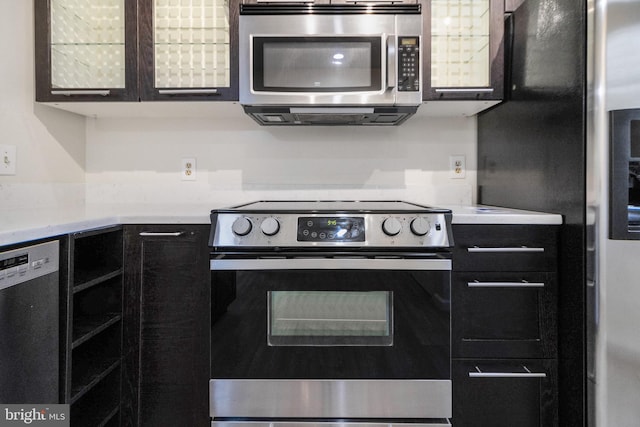 kitchen with light countertops, black appliances, and dark cabinetry