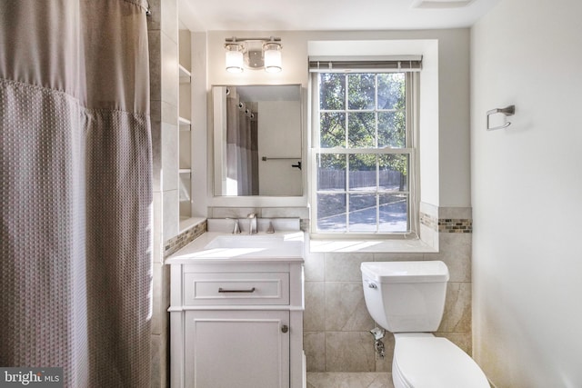 bathroom featuring a shower with curtain, tile walls, and vanity