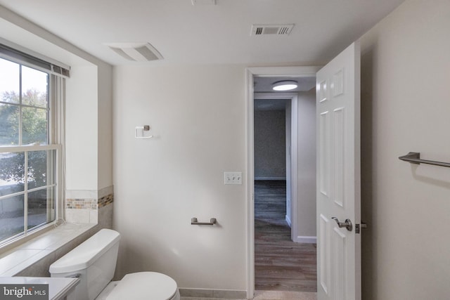 bathroom featuring visible vents, toilet, and wood finished floors