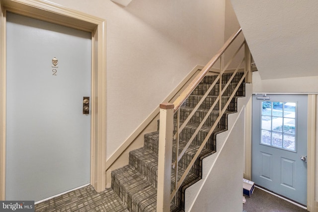 stairway featuring a textured ceiling