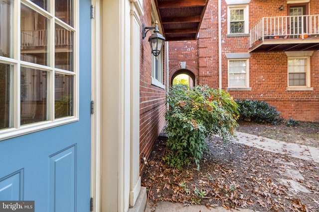 view of exterior entry featuring brick siding