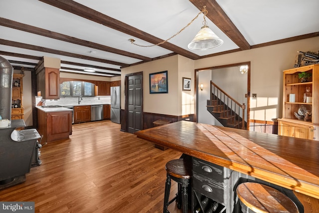 dining room featuring sink, beamed ceiling, and hardwood / wood-style flooring