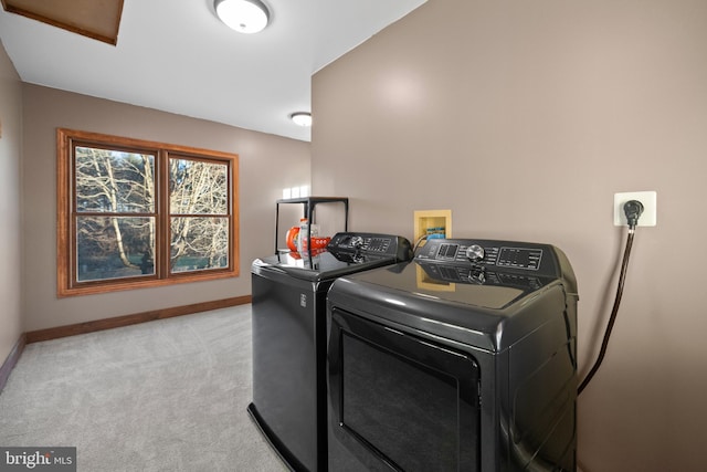 laundry area featuring washing machine and clothes dryer and light colored carpet