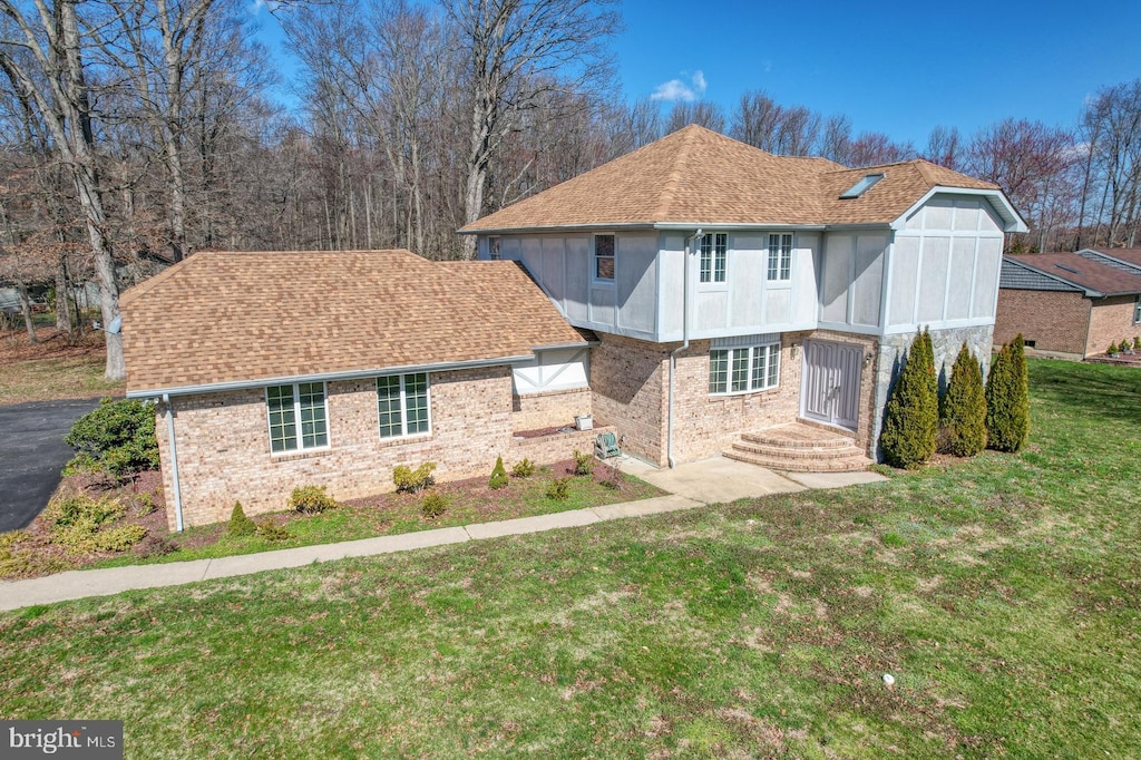 rear view of house with a lawn and a sunroom